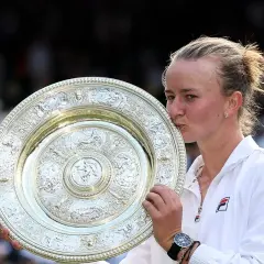 Tenisistka całuje puchar Wimbledonu.